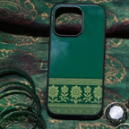 Green phone case with decorative pattern on a green fabric background